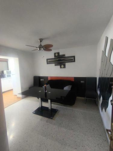 a living room with a bed and a ceiling fan at Soluna Alcala in Alcalá del Río