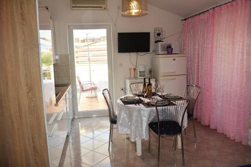 uma sala de jantar com uma mesa com cadeiras e um frigorífico em Apartment Vesna em Ravni