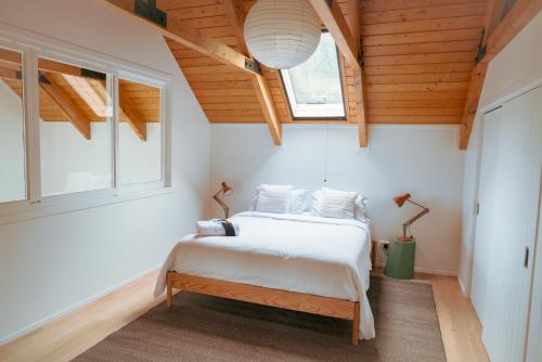 a bedroom with a bed in a room with wooden ceilings at Matakana Retreat - Luxury Off Grid Lodge in Nature in Matakana