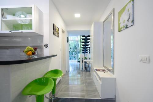 une cuisine avec un comptoir et des tabourets verts dans l'établissement Apartments Mali Stradun, à Dubrovnik