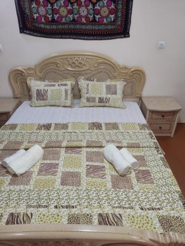 un letto con due cuscini e una trapunta sopra di Amirjon Hostel Samarkand a Samarkand