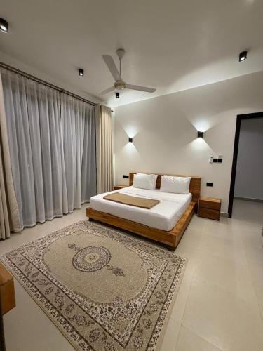 a bedroom with a large bed and a rug at Zanziluxe Residences in Zanzibar City