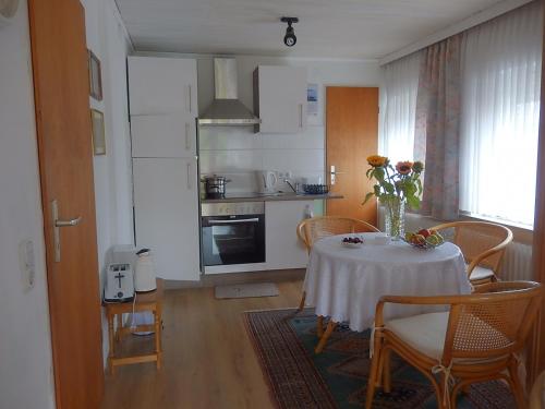 a kitchen with a table with a vase of flowers on it at Ferienwohnung Sonnenblume in Leer