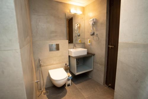 a bathroom with a toilet and a sink and a mirror at Hotel Crown Plaza in Kathmandu