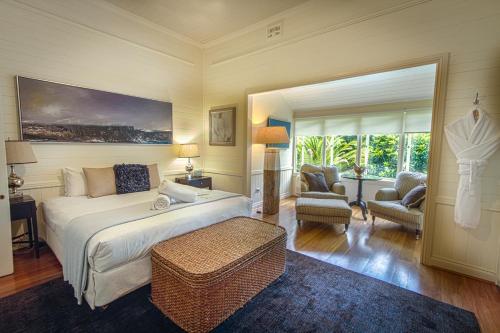 a bedroom with a large bed and a living room at Bangalow Guesthouse in Bangalow