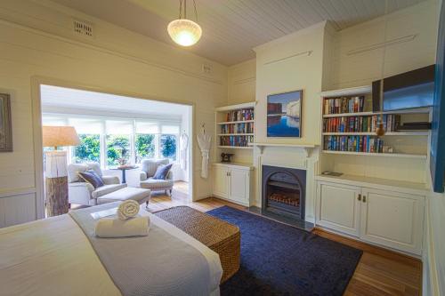 a room with a fireplace and a living room with a bed at Bangalow Guesthouse in Bangalow
