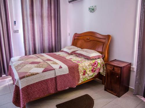 a bedroom with a bed with a quilt and a table at Bano Beach Residence - Grand Bay Beach in Grand Baie