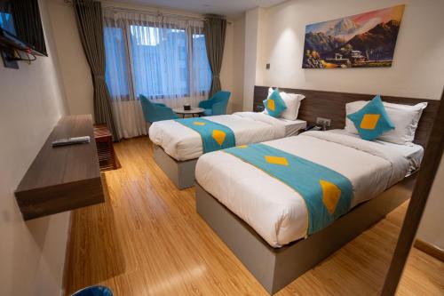 a hotel room with two beds and a desk at Hotel Crown Plaza in Kathmandu