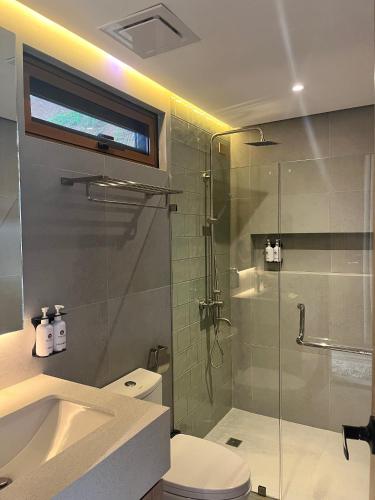 a bathroom with a shower and a toilet and a sink at Kenjelo Farm and Recreation Resort in Dullan