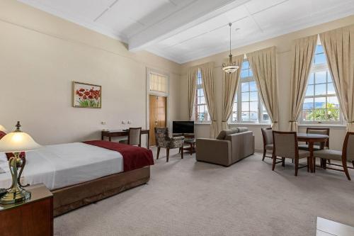 a hotel room with a bed and a living room at Quality Hotel Regent Rockhampton in Rockhampton
