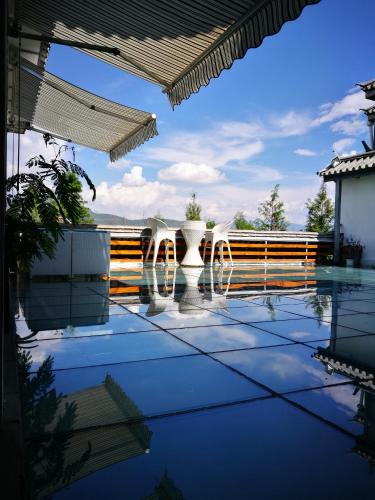 a view of a pool with white chairs on a patio at Erhaike Seaview Inn in Dali