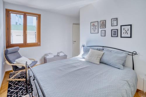 a bedroom with a bed and a chair and a window at Casa Altea in Pordenone