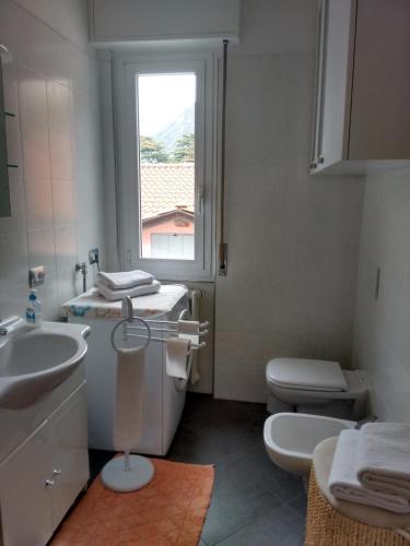 a bathroom with a sink and a toilet and a window at Gardens House in Varenna