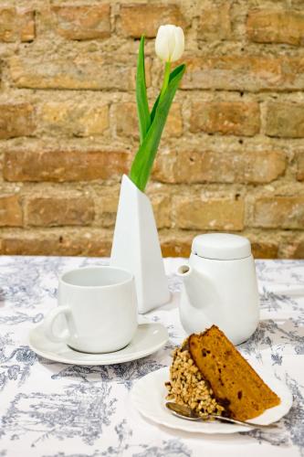 a table with two cups and a vase with a flower at Ivolita Vilnius in Vilnius