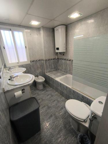 a bathroom with a toilet and a sink and a tub at Soluna Alcala in Alcalá del Río