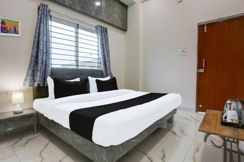 a bedroom with a large bed and a window at Hotel O Grand Embassy in Mānglia