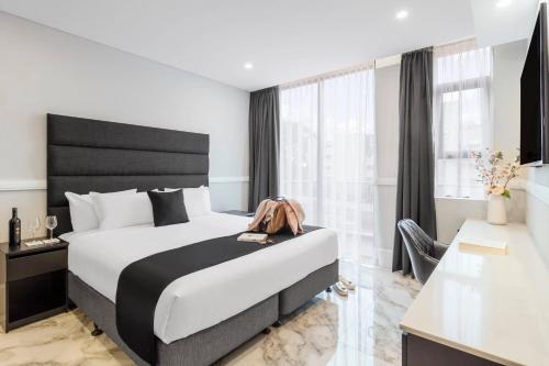 a bedroom with a large bed with a black headboard at Gladius Hotels & Suites Parramatta, an Ascend Hotel Collection in Parramatta