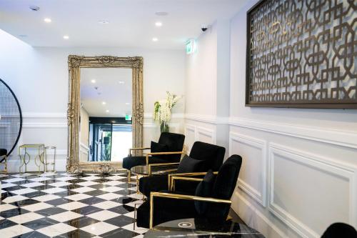 a waiting room with chairs and a mirror at Gladius Hotels & Suites Parramatta, an Ascend Hotel Collection in Parramatta