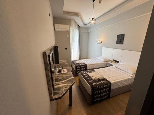 a small room with two beds and a mirror at Aslan City Hotel - Ex Beste Hotel in Alanya