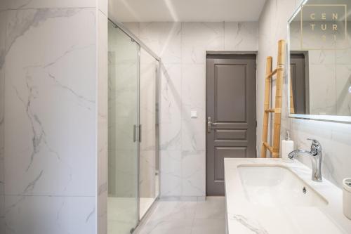 a bathroom with a sink and a glass shower at Philippe chez l'habitant in Maubeuge