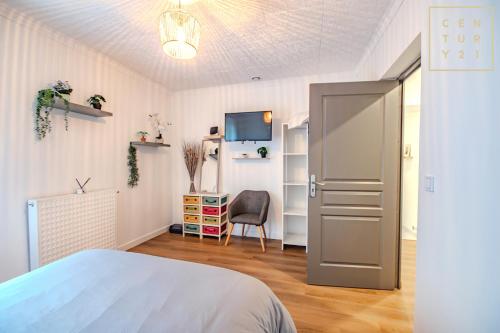 a bedroom with a bed and a desk with a chair at Philippe chez l'habitant in Maubeuge