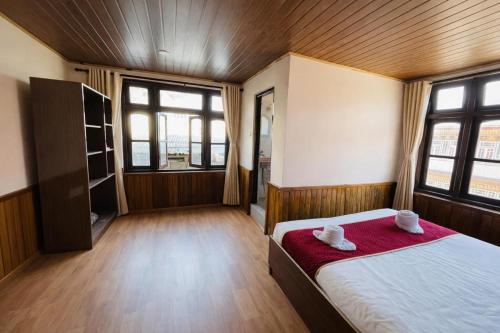 a bedroom with a bed with two towels on it at Hotel Tashiling Stay in Pelling