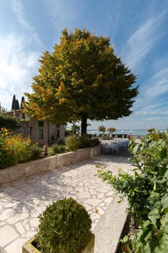 a tree in a patio with a table and a tree at Villa Pioppi Hotel in Sirmione