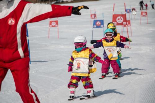 a group of children are skiing in the snow at Landhotel Berger in Eben im Pongau