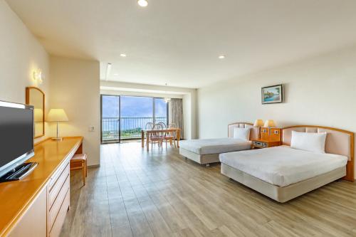 a hotel room with two beds and a flat screen tv at YU-FURI Izukogen in Ito