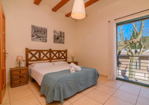 a bedroom with a bed and a large window at Cal Metge de Gualba in gualba de Dalt