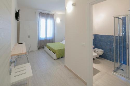 uma pequena casa de banho com uma cama e um WC em Affittacamere Margherita em La Spezia