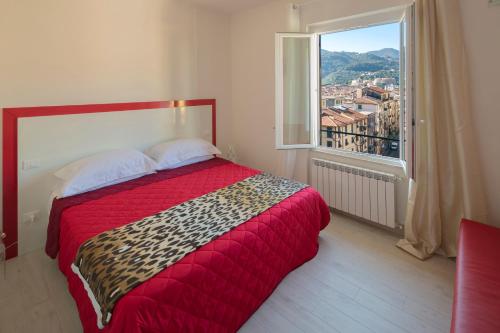 a bedroom with a red bed and a large window at Affittacamere Margherita in La Spezia