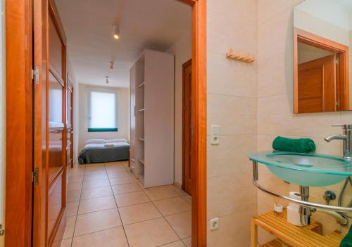 a bathroom with a blue sink and a bedroom at Cal Metge de Gualba in gualba de Dalt