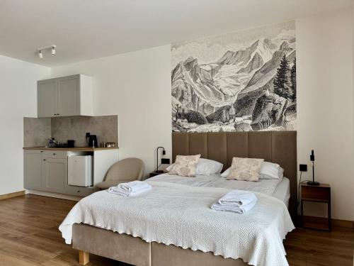 a bedroom with a large bed and a painting on the wall at Tatrini in Białka Tatrzańska