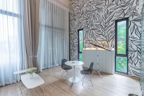 a room with a table and two chairs and a wall with aanova at Heaven Sukhumvit 62Villa in Bangkok