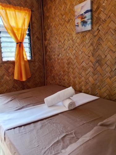 a bed in a room with a window and a curtain at C and C Place in San Vicente