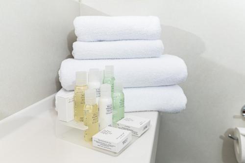 a pile of towels and bottles on a shelf in a bathroom at Hotel Euro in Pardubice