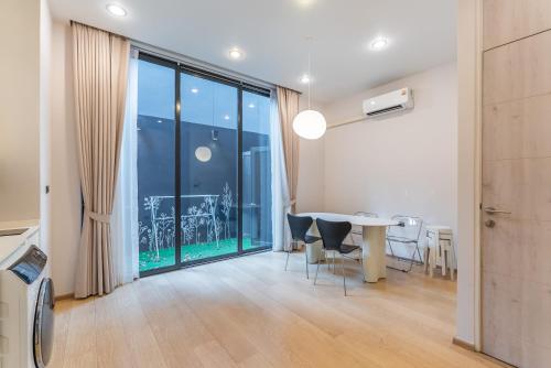 a dining room with a table and a large window at Heaven Sukhumvit 62Villa in Bangkok