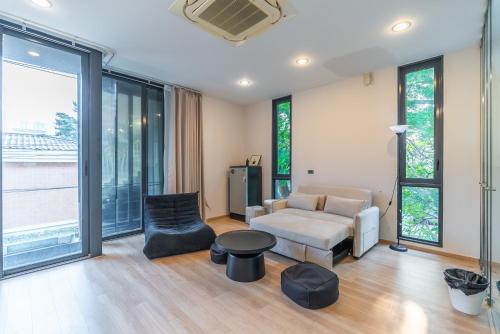 a living room with a couch and a chair at Heaven Sukhumvit 62Villa in Bangkok