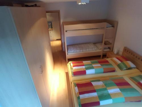 ein kleines Schlafzimmer mit einem Bett und einem Etagenbett in der Unterkunft Haus Jelini in Schnepfau