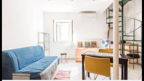 een woonkamer met een blauwe bank en een tafel bij Napoli sotterranea apartment in Napels