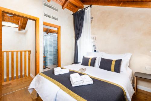 a bedroom with a bed with two towels on it at Luxury Jerini House with pool and wellness in Bajčići