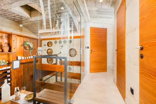 a tasting room with wooden walls and a glass door at Luxury Jerini House with pool and wellness in Bajčići
