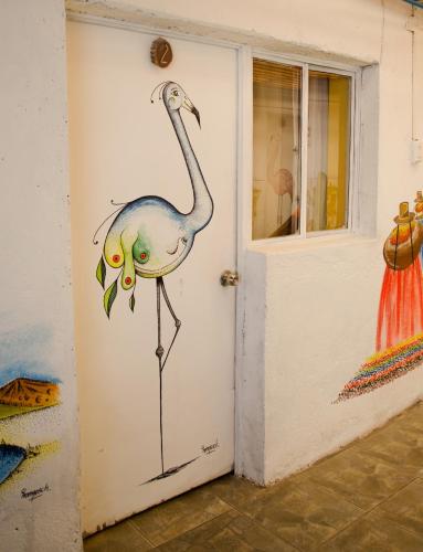 a door with a painting of a flamingo on it at Hostal Kirckir in San Pedro de Atacama