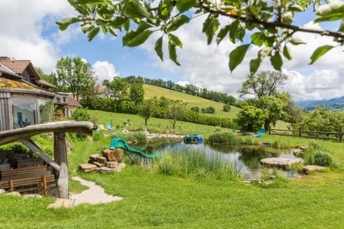 a garden with a pond and a house at Biohof Ebenbauer in Waidhofen an der Ybbs