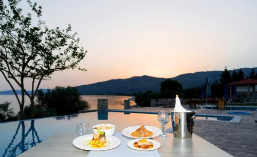 a table with plates of food and wine glasses at Thesmos Village in Mýtikas