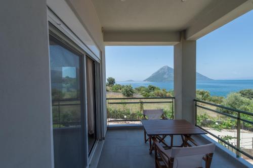 a balcony with a table and a view of the ocean at Thesmos Village in Mýtikas