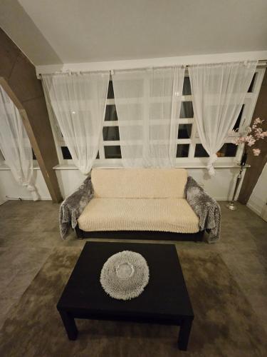 a living room with a couch and a table at Die kurPark Eule in Mölln