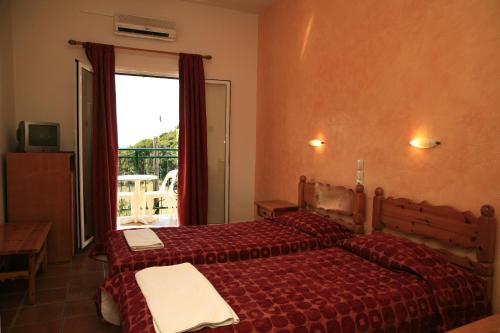 a hotel room with two beds and a window at Apollon Annexe in Paleokastritsa
