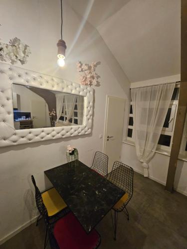a dining room with a table and chairs and a mirror at Die kurPark Eule in Mölln